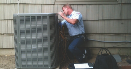 A technician working on an hvac air handler