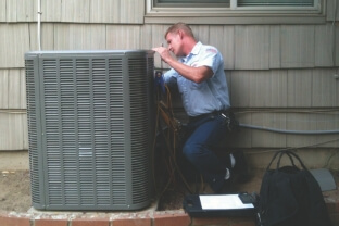 A technician doing maintenance on an air handler