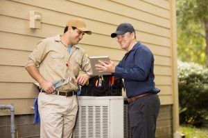 two-professionals-looking-over-air-conditioner