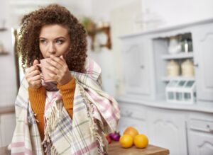 woman-with-blanked-on-her-sipping-from-mug