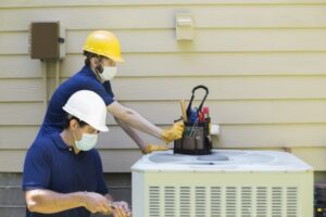 two-air-conditioner-technicians-working-on-air-conditioner