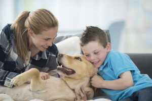 Happy family with a dog relaxing indoors, enjoying comfort provided by a heat pump HVAC system.